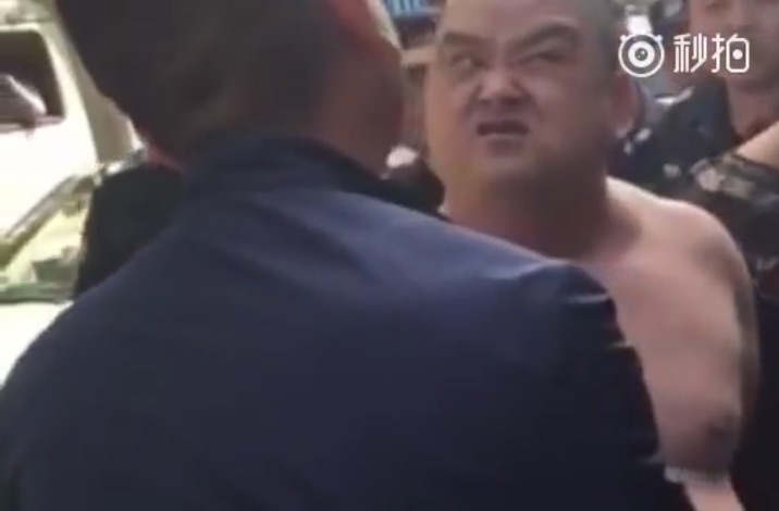 Un homme torse nu, portant un hachoir, intimide la police chinoise