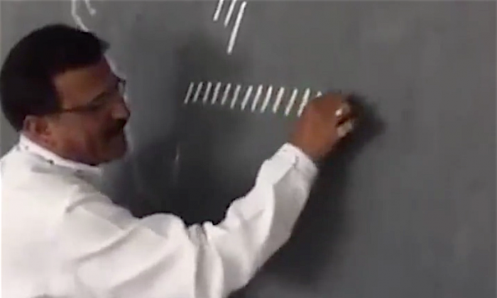 Un enseignant dessine une rangée de traits sur son tableau noir, puis subtilement crée un alphabet cursif