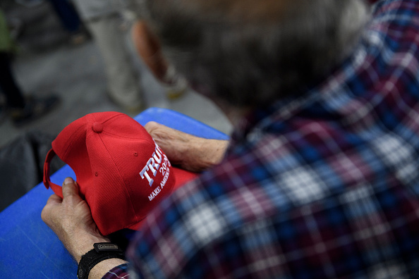 Des manifestants anti-Trump brûlent un drapeau américain et des chapeaux MAGA à Minneapolis