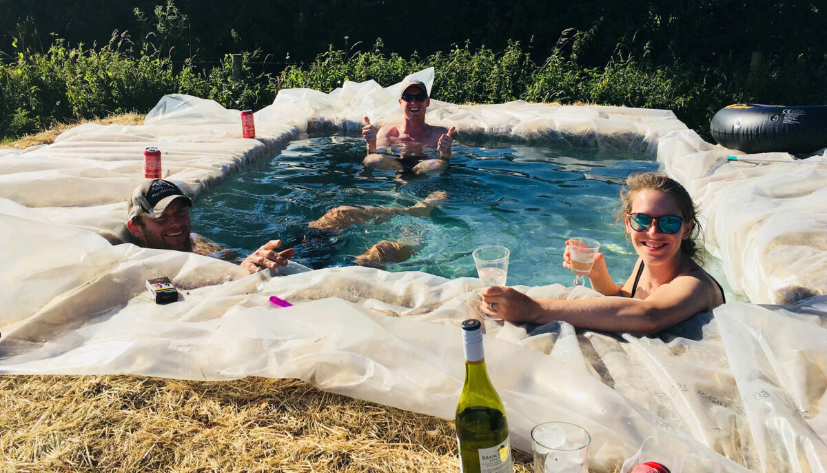 Une famille construit une piscine improvisée avec des bottes de foin dans son jardin pendant la canicule