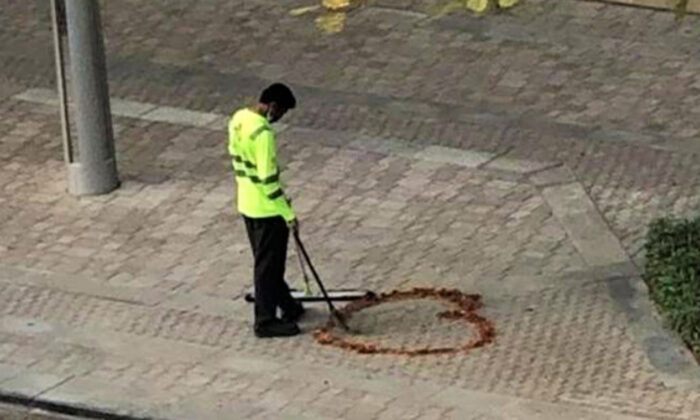 Un agent de propreté dessine un cœur sur le trottoir avec des feuilles, il lui tarde de revoir sa famille au milieu de la pandémie